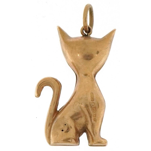 2068 - 9ct gold charm in the form of a seated cat with red glass eyes, 2.5cm high, 1.3g