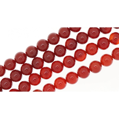 2368 - Two carnelian bead necklaces, one with a Chinese white metal clasp, 66cm and 42cm in length, total 9... 