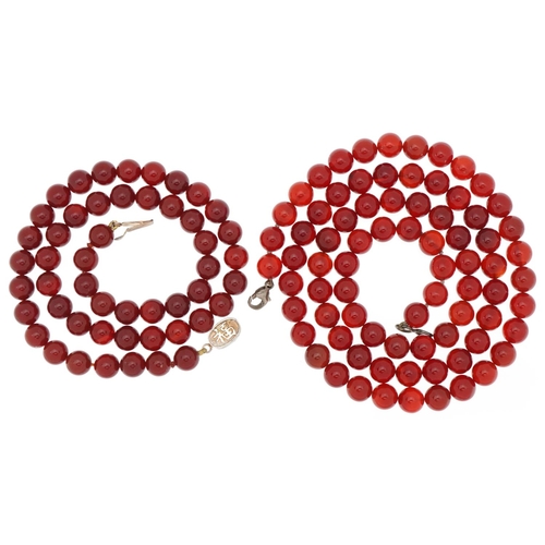 2368 - Two carnelian bead necklaces, one with a Chinese white metal clasp, 66cm and 42cm in length, total 9... 