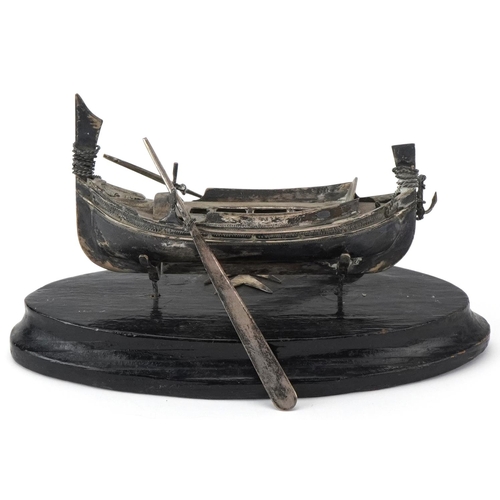 514 - Maltese unmarked silver model of a fishing boat raised on an ebonised wood stand, overall 14cm in le... 