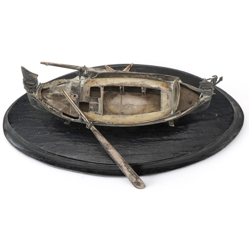 514 - Maltese unmarked silver model of a fishing boat raised on an ebonised wood stand, overall 14cm in le... 