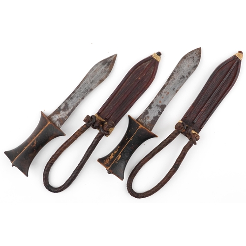 531 - Pair of African Tribal daggers with wooden handles housed in leather sheaths having rope twist strap... 