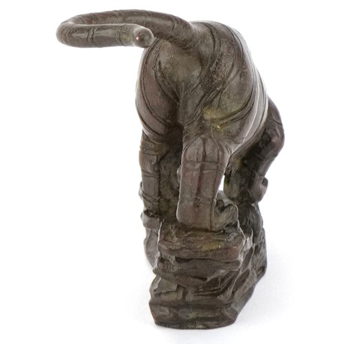 296 - Japanese patinated bronze tiger on a rock, 13cm in length