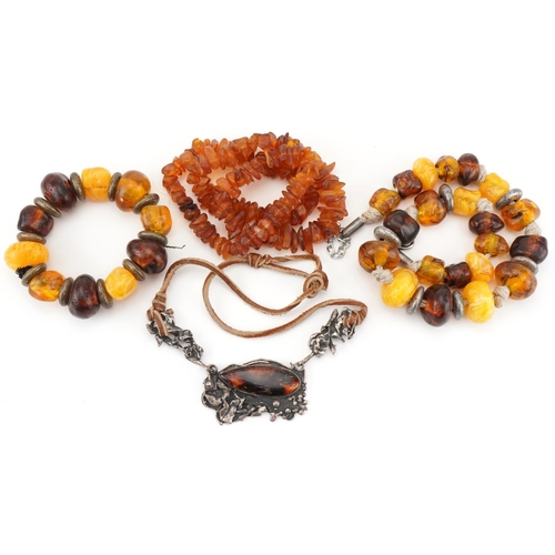 2692 - Four Baltic and natural amber necklaces, one with naturalistic white metal setting, total weight 290... 