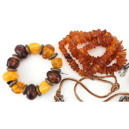 2692 - Four Baltic and natural amber necklaces, one with naturalistic white metal setting, total weight 290... 