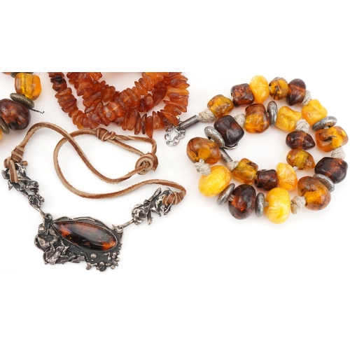 2692 - Four Baltic and natural amber necklaces, one with naturalistic white metal setting, total weight 290... 