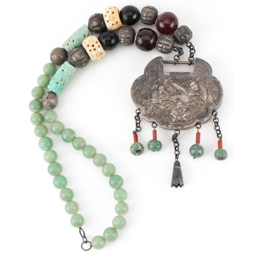 2700 - Large Chinese white metal, jade and amber coloured bead necklace embossed with figures seated at a t... 