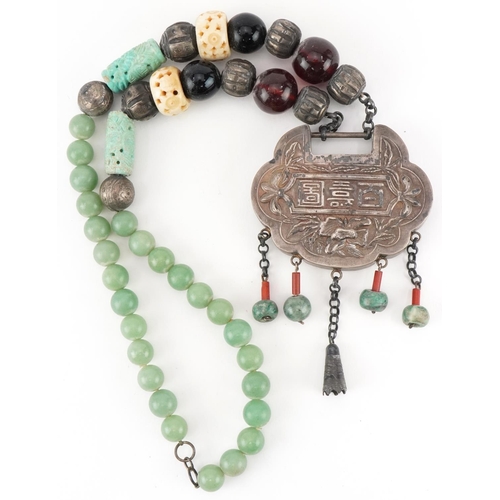 2700 - Large Chinese white metal, jade and amber coloured bead necklace embossed with figures seated at a t... 