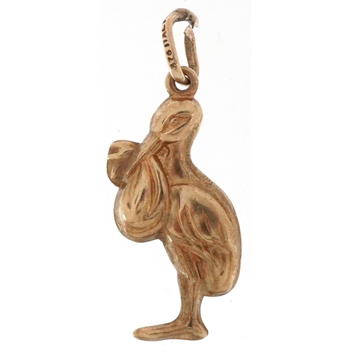 2213 - 9ct gold charm in the form of a stork carrying a newborn baby, 2.7cm high, 1.1g