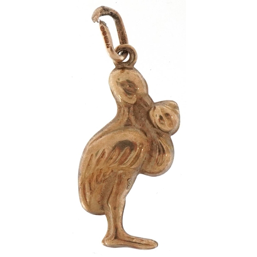 2213 - 9ct gold charm in the form of a stork carrying a newborn baby, 2.7cm high, 1.1g