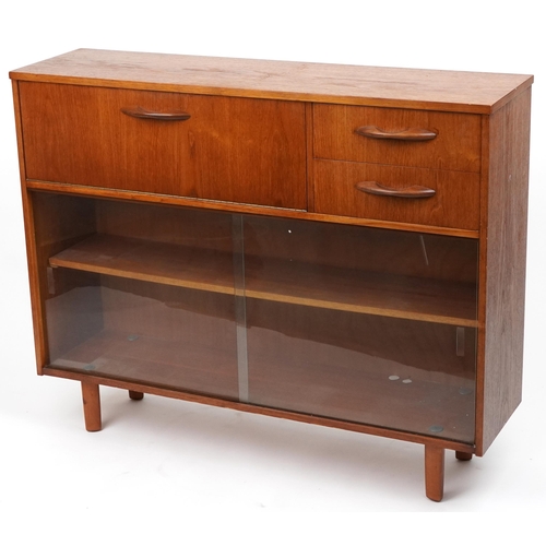 1106A - Avalon, mid century teak side cabinet fitted with a fall and two drawers above a pair of glass slidi... 