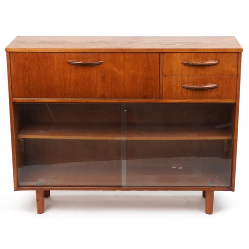 1106A - Avalon, mid century teak side cabinet fitted with a fall and two drawers above a pair of glass slidi... 