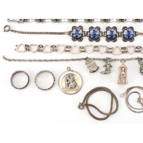 2694 - Vintage and later silver and white metal jewellery including a charm bracelet, floral engraved locke... 