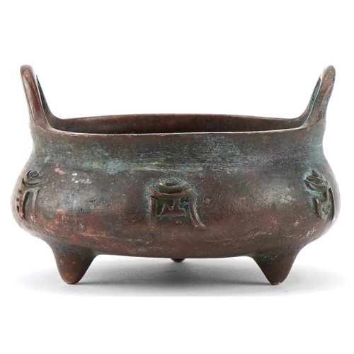 1433 - Chinese patinated bronze three footed censer with twin handles, 8cm wide