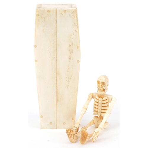 1464 - Novelty carved bone articulated model of a human skeleton housed in a sectional bone coffin, 11.5cm ... 