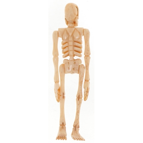 1464 - Novelty carved bone articulated model of a human skeleton housed in a sectional bone coffin, 11.5cm ... 