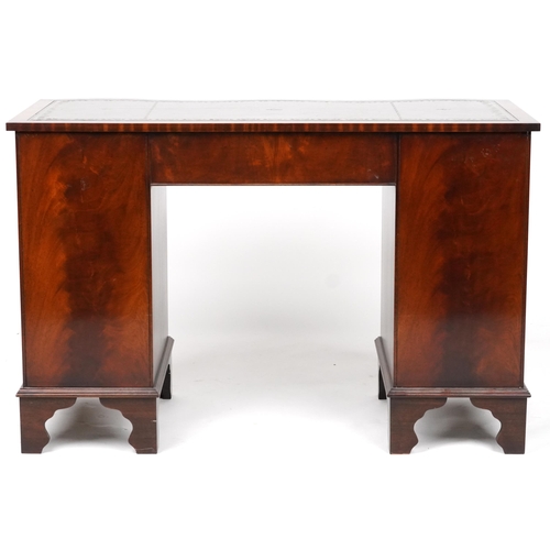 1012 - Mahogany serpentine front twin pedestal desk and a mahogany chair, the desk with nine drawers and gr... 