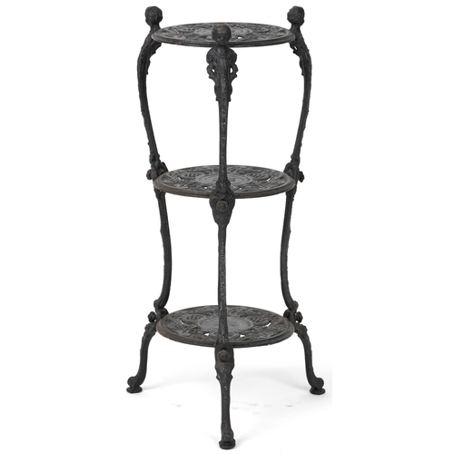 1089 - Victorian style cast iron three tier plant stand with figural mounts, 74cm high