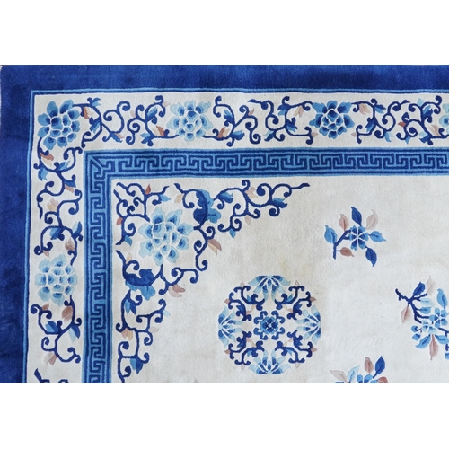 1123 - Large Chinese blue and cream ground rug having an allover floral design, 370cm x 275cm