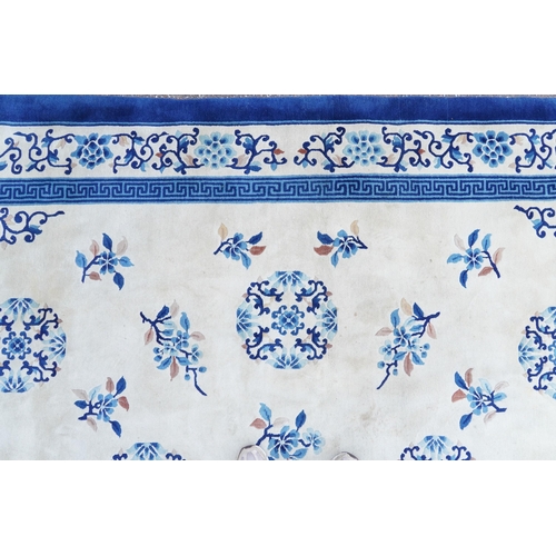 1123 - Large Chinese blue and cream ground rug having an allover floral design, 370cm x 275cm