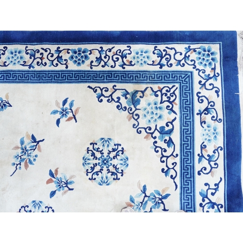 1123 - Large Chinese blue and cream ground rug having an allover floral design, 370cm x 275cm