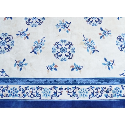 1123 - Large Chinese blue and cream ground rug having an allover floral design, 370cm x 275cm