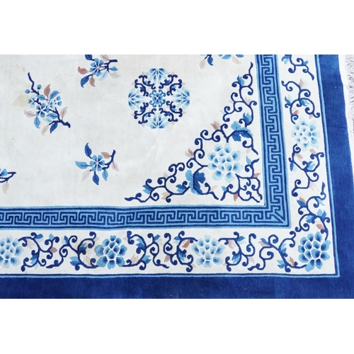 1123 - Large Chinese blue and cream ground rug having an allover floral design, 370cm x 275cm