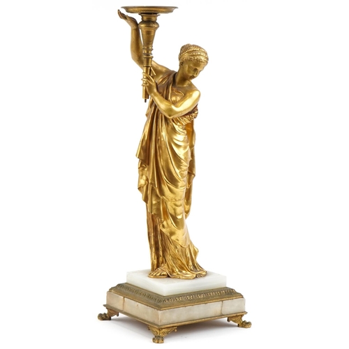 19th century classical gilt bronze statue of a lady holding a torch, mounted on a marble and bronze lion paw base, numbered 21369 to base, 60cm high