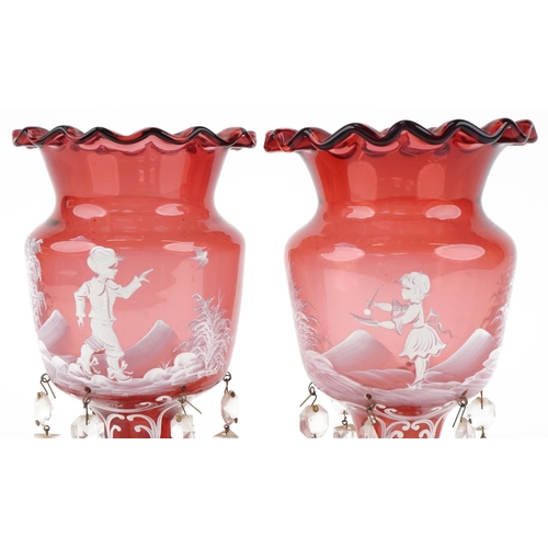 200 - Pair of Victorian cranberry Mary Gregory glass lustres enamelled with children at play, each 26cm hi... 