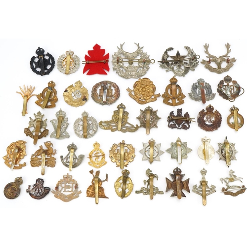 1518 - Approximately forty military cap badges, to include Royal Berkshire Regiment, Lancashire Hussars and... 