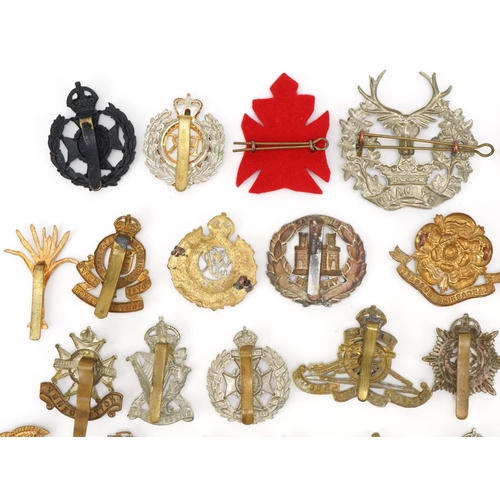 1518 - Approximately forty military cap badges, to include Royal Berkshire Regiment, Lancashire Hussars and... 