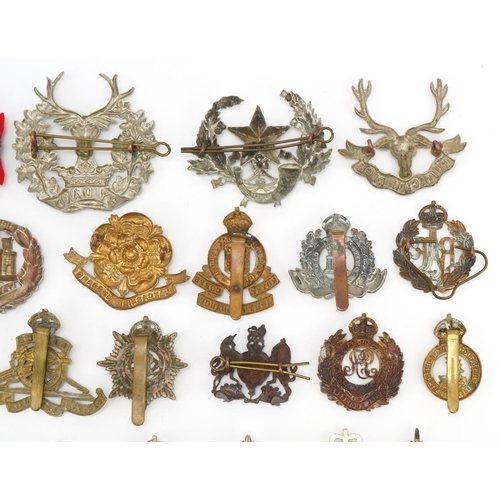 1518 - Approximately forty military cap badges, to include Royal Berkshire Regiment, Lancashire Hussars and... 