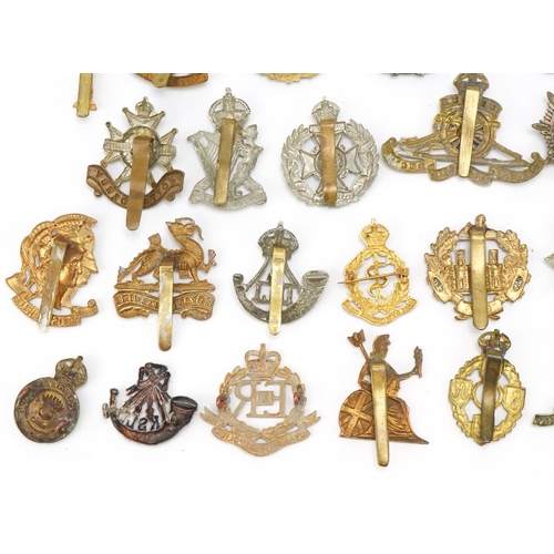 1518 - Approximately forty military cap badges, to include Royal Berkshire Regiment, Lancashire Hussars and... 