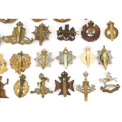 1518 - Approximately forty military cap badges, to include Royal Berkshire Regiment, Lancashire Hussars and... 