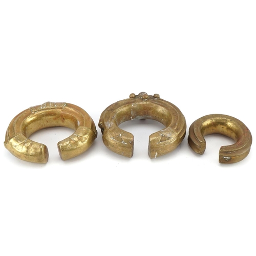 126 - Three tribal interest African brass cuff bangles, the largest 12cm in diameter