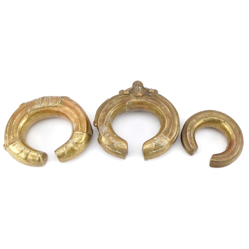 126 - Three tribal interest African brass cuff bangles, the largest 12cm in diameter