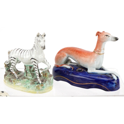 185 - Victorian Staffordshire dogs including an inkwell example and a Staffordshire zebra, the largest 17c... 