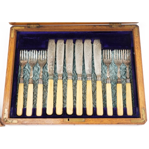 386 - Oak canteen of twelve silver plated fish knives and forks with ivorine handles, the canteen 35cm wid... 