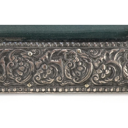 2445 - Indian style silver easel photo frame profusely embossed with flowers and foliage, G C & Co maker's ... 