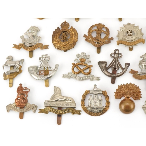 1519 - Approximately forty military cap badges to include Royal Warwickshire, Cornwall Light Infantry, Dors... 