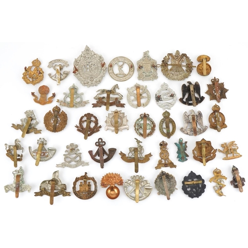 1519 - Approximately forty military cap badges to include Royal Warwickshire, Cornwall Light Infantry, Dors... 