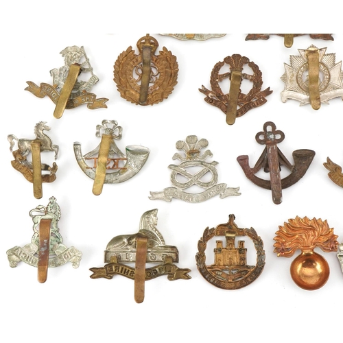 1519 - Approximately forty military cap badges to include Royal Warwickshire, Cornwall Light Infantry, Dors... 