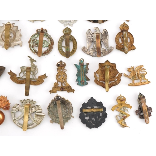 1519 - Approximately forty military cap badges to include Royal Warwickshire, Cornwall Light Infantry, Dors... 