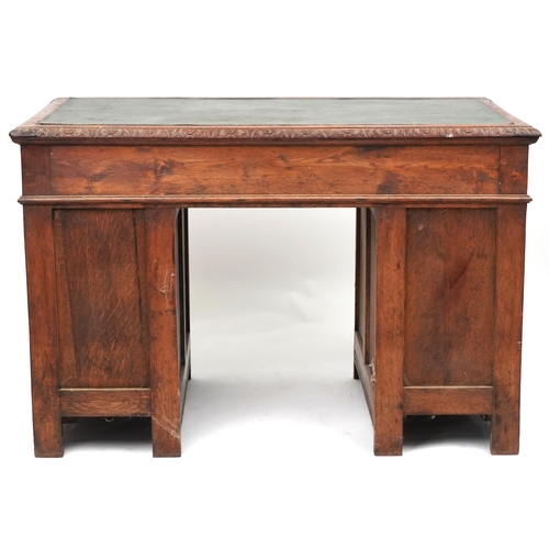 1003 - Victorian oak twin pedestal desk carved with a green man masks, fitted with an arrangement of nine d... 