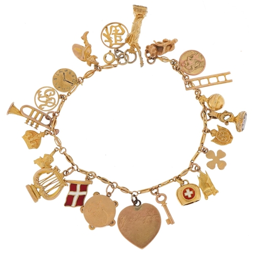 9ct gold charm bracelet with a collection of 9ct gold, 18ct gold and yellow metal charms including Statue of Liberty, koala, St Christopher and trumpet, total 42.8g