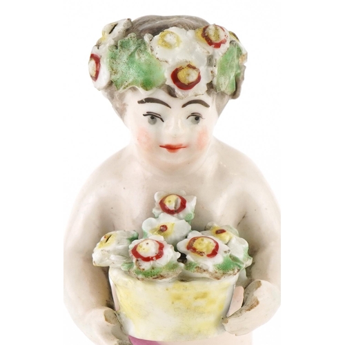 184 - 18th century hand painted porcelain model of a Putti with basket of flowers, 10cm high