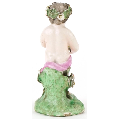 184 - 18th century hand painted porcelain model of a Putti with basket of flowers, 10cm high