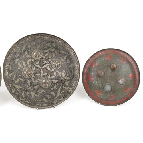 228 - Four Indo-Persian bronze Dhal shields decorated with flowers, the largest 38cm