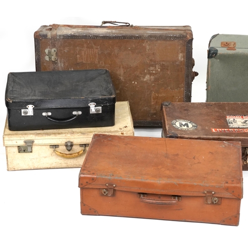 406 - Eight vintage and later suitcases, some leather, the largest 76cm wide