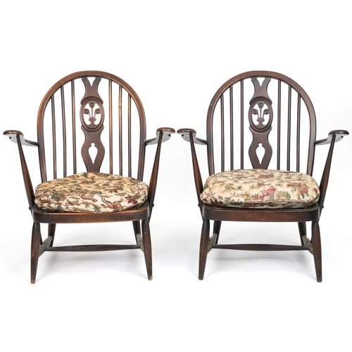 1017 - Two Ercol elm stick back open armchairs with Prince of Wales feather carved backs, each 80cm high